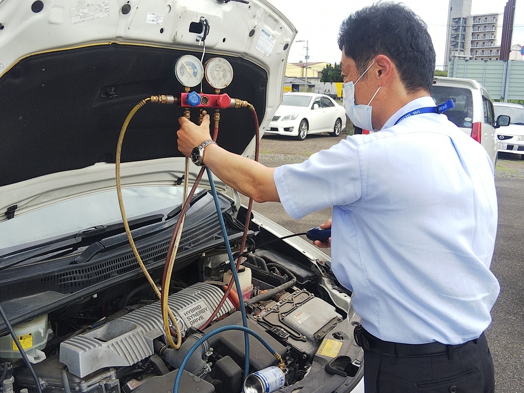 画像：車のバンパーを開けて作業をする男性